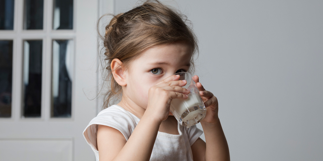 Young girl drinking from a milk glass